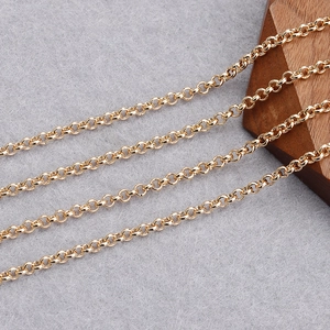 Macro view of 18K gold plated rollo chain links on a gray felt background