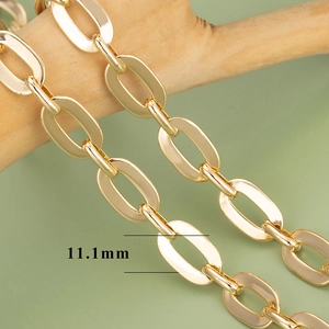 Close-up of 11.1mm wide 18K gold plated cross chain links on a wooden branch detail