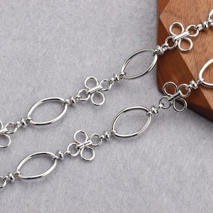 Close-up of silver-tone polished metal chain with oval rings and clover connectors
