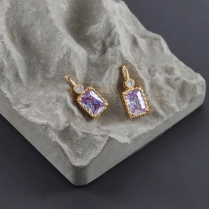 Detail view of rectangular purple zircon pendants with 18k gold plating on stone base