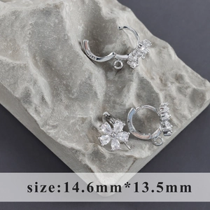 Macro shot of S925 sterling silver floral huggie hoops with clear zircon petals