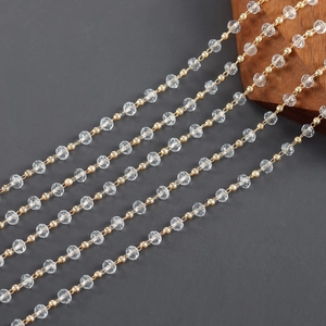 Detailed macro of 18k gold plated chain featuring faceted clear crystal beads