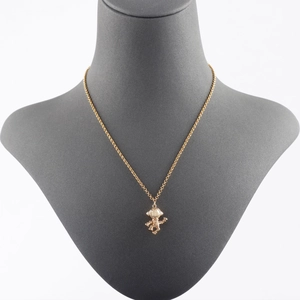 Collar con colgante de astronauta chapado en oro de 18k mostrado en un busto de joyería