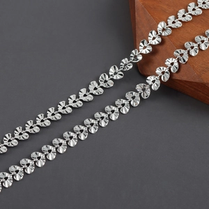 Close-up of 18k rhodium plated heart-shaped chain links with textured ripple patterns