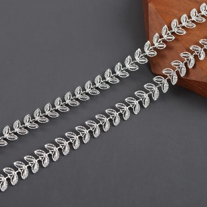 Macro detail of silver leaf-shaped metal chain with textured matte finish for DIY jewelry
