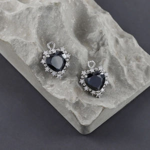 Détail de pendentifs en forme de cœur dorés 18 carats avec zircon noir et griffes