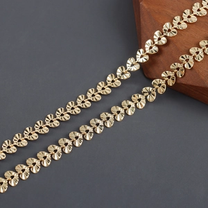 Detailed close-up of 18k gold plated heart-shaped chain links with textured radial patterns