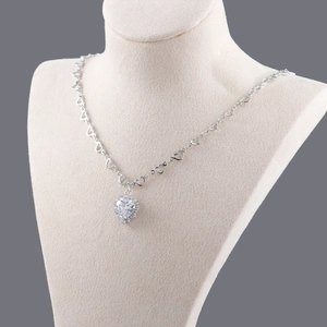 Collier avec pendentif cœur plaqué or blanc 18k et zircone cubique sur présentoir beige