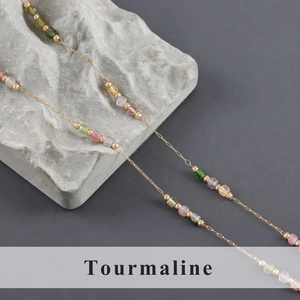 Detail of multi-colored natural tourmaline beads on a minimalist gold beaded chain