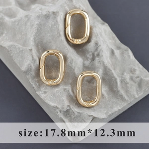 Dettaglio di moschettoni ovali dorati per gioielli 17,8x12,3mm su sfondo in pietra