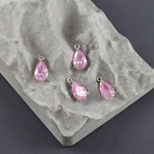 Detailed view of pear-shaped pink zircon pendants with silver plated 4-prong setting