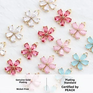 Detailed macro view of four-leaf flower charms with zircon petals in 18k gold plating