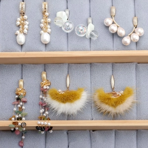 Various 18k gold plated earring styles with pearls and tassels in a gray velvet jewelry box