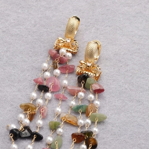 Bohemian gold plated 18k drop earrings with colorful stones and tassels on felt background