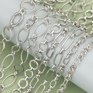 Various textured silver chain designs for DIY jewelry making on a light blue display stand