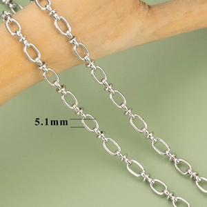 5.1mm silver chain links for jewelry making wrapped around a wooden branch on green background