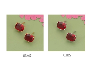 Macro-detail van 18k vergulde bedeltjes met rood glas en ophangoog voor DIY-sieraden