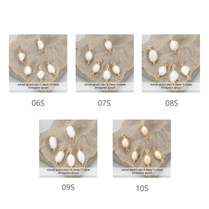Vue macro de cinq breloques en perles d'eau douce irrégulières avec boucles dorées pour bijoux