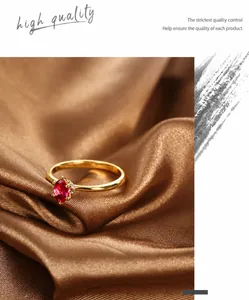Macro detail of gold-plated ring with red oval gemstone on textured brown silk