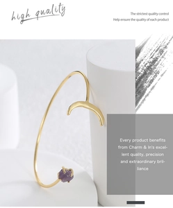 Detailaufnahme der goldenen Mond-Armspange mit violettem Naturstein und Metallreif