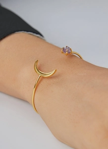 Details des eleganten Mondarmreifs in Gold mit einem lila Naturstein-Akzent