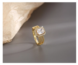 Détail macro d'une bague dorée avec zircon rectangulaire et sertissage pavé à trois rangs