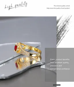 Vue macro de la bague dorée avec zircon rouge ovale et cristaux micro-incrustés