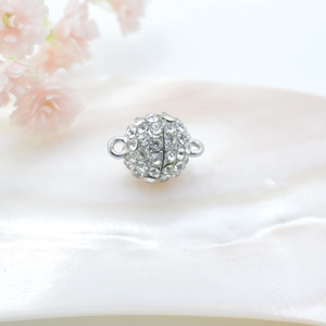 Dettaglio di una chiusura magnetica sferica in argento con strass per gioielli fai da te
