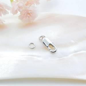 Silberner Karabinerverschluss und Biegering für DIY-Schmuck auf Muschelschale