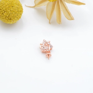 Close-up of rose gold hexagonal star pendant with zircons and pearl needle tray