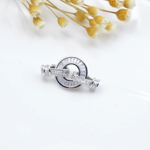 Close-up of a silver necklace clasp with micro-pave baguette-cut zircons and shiny metal