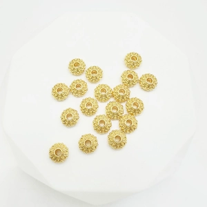 Perles d'espacement lotus dorées plates pour bijoux DIY sur une plateforme blanche