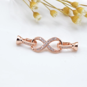 Infinity shape rose gold jewelry connector with micro-set zircons on white background