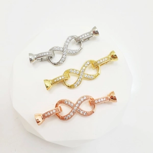 Macro view of infinity-shaped jewelry connectors with sparkling cubic zirconia settings