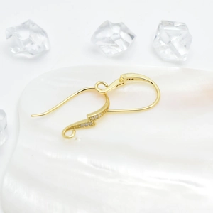 18k gold plated lightning bolt earrings with zircons on a white shell tray