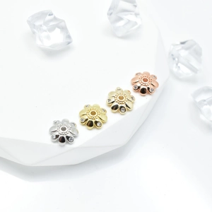 Macro detail of daisy flower petal spacers with micro-pave zircons in four metallic colors