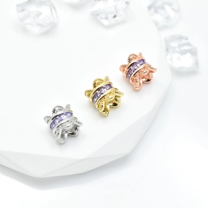 Three colors of micro-pave zirconia butterfly beads on white stone with crystal decor