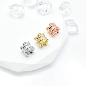 Three-color zircon barrel beads set in silver, gold, and rose gold on display stand