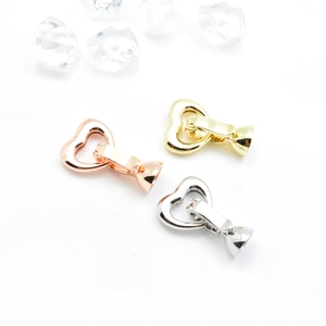 Polished heart-shaped jewelry clasps in rose gold, gold, and silver finishes on white background