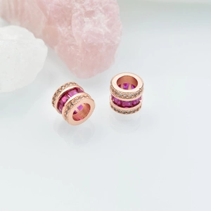 18K rose gold-plated beads with pink square stones and micro-pave diamonds on white surface