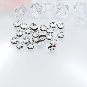 Detalle de cuentas espaciadoras plateadas de 6mm con cristales ámbar oscuro y bordes de encaje