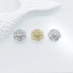 Macro detail of gold and silver flower bead caps with sparkling cubic zirconia settings