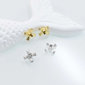 Cross-shaped jewelry spacers in gold and silver with radial texture and zircon settings