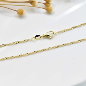 Macro shot of 18K gold plated necklace with delicate twisted chain and lobster clasp