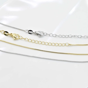 Dettaglio di catene veneziane oro e argento con chiusure a moschettone ed estensione per collane