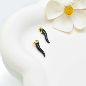 Elegant pair of black enamel Italian horn pendants with golden rings on white surface