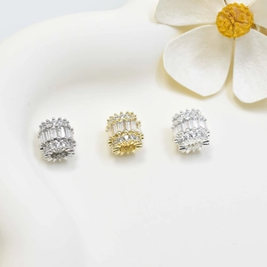 Three premium cylinder beads with pavé-set zircons on white decorative tray
