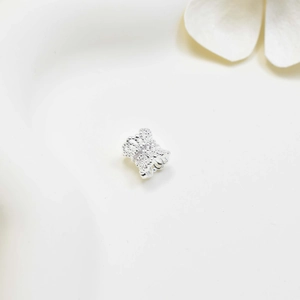 Silver bow-shaped spacer charm with hollow lace design and white zircon inlays