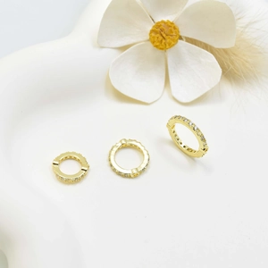 Gold circular jewelry spacers with pavé zircon settings on white decorative tray