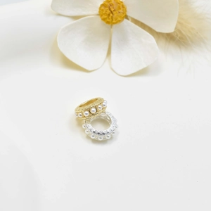 Bagues texturées en or et argent avec perles incrustées sur fond floral élégant